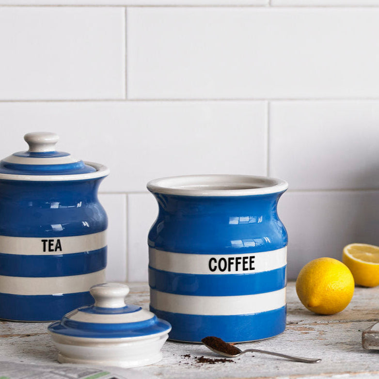 Set of Cornishware blue ceramic canisters labeled 'Tea', 'Coffee', and 'Sugar' on a kitchen counter.
